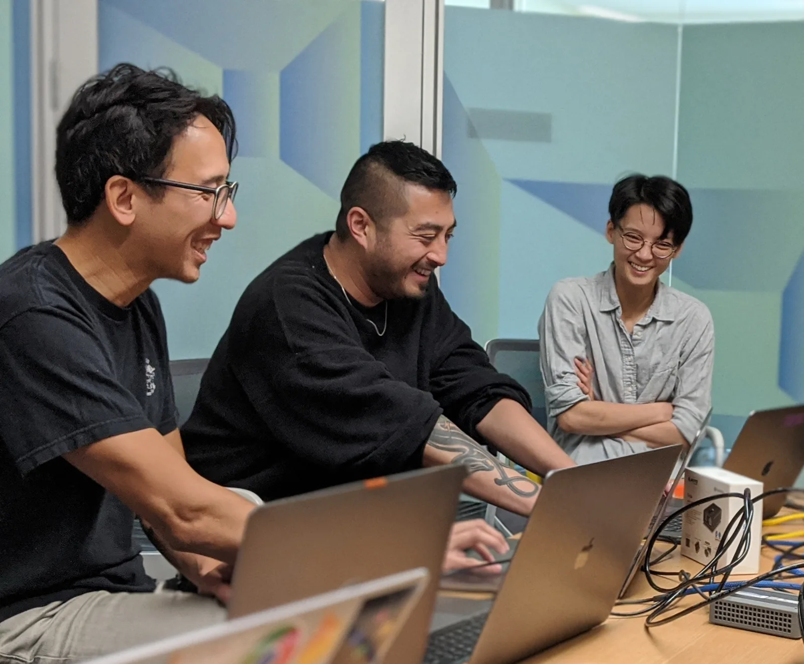 Developer advocates laughing together during a hands-on content creation workshop.